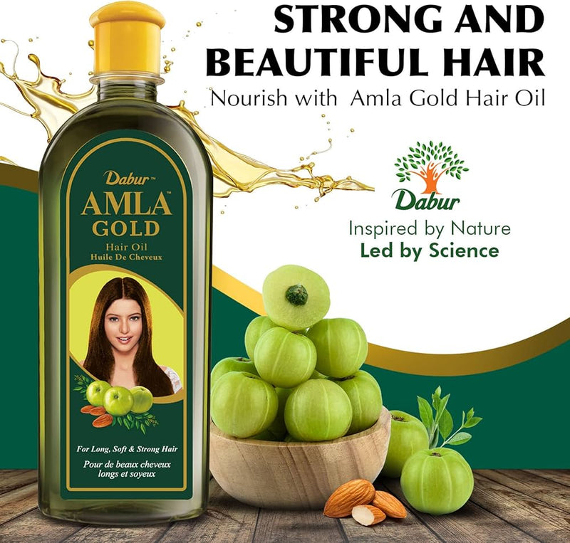 Flacon de Dabur Amla Gold Huile Capillaire 300ml posé sur une table, entouré de feuilles vertes