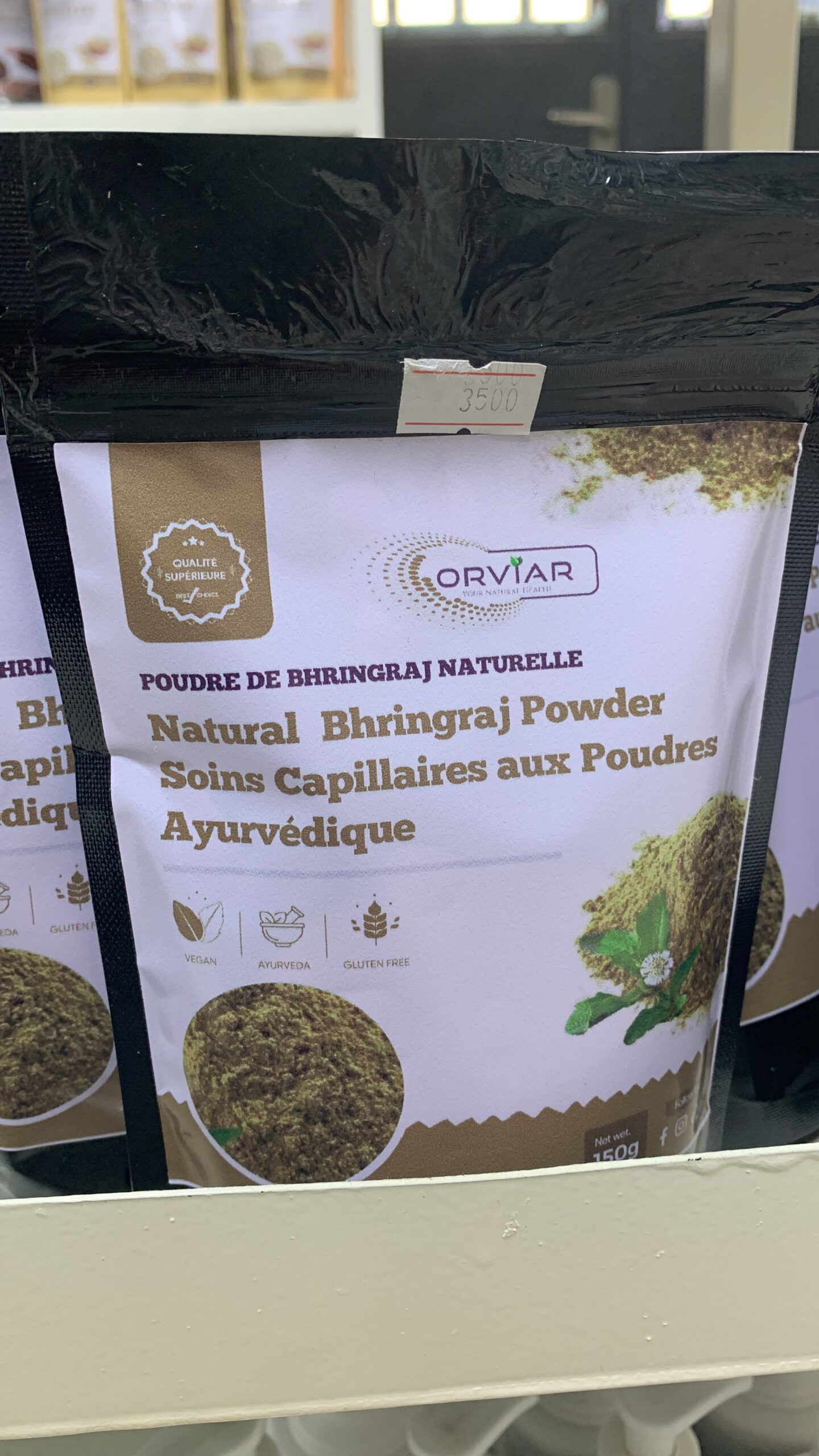 Détail de la poudre ayurvédique fine et de couleur verte, présentée dans un bol en céramique